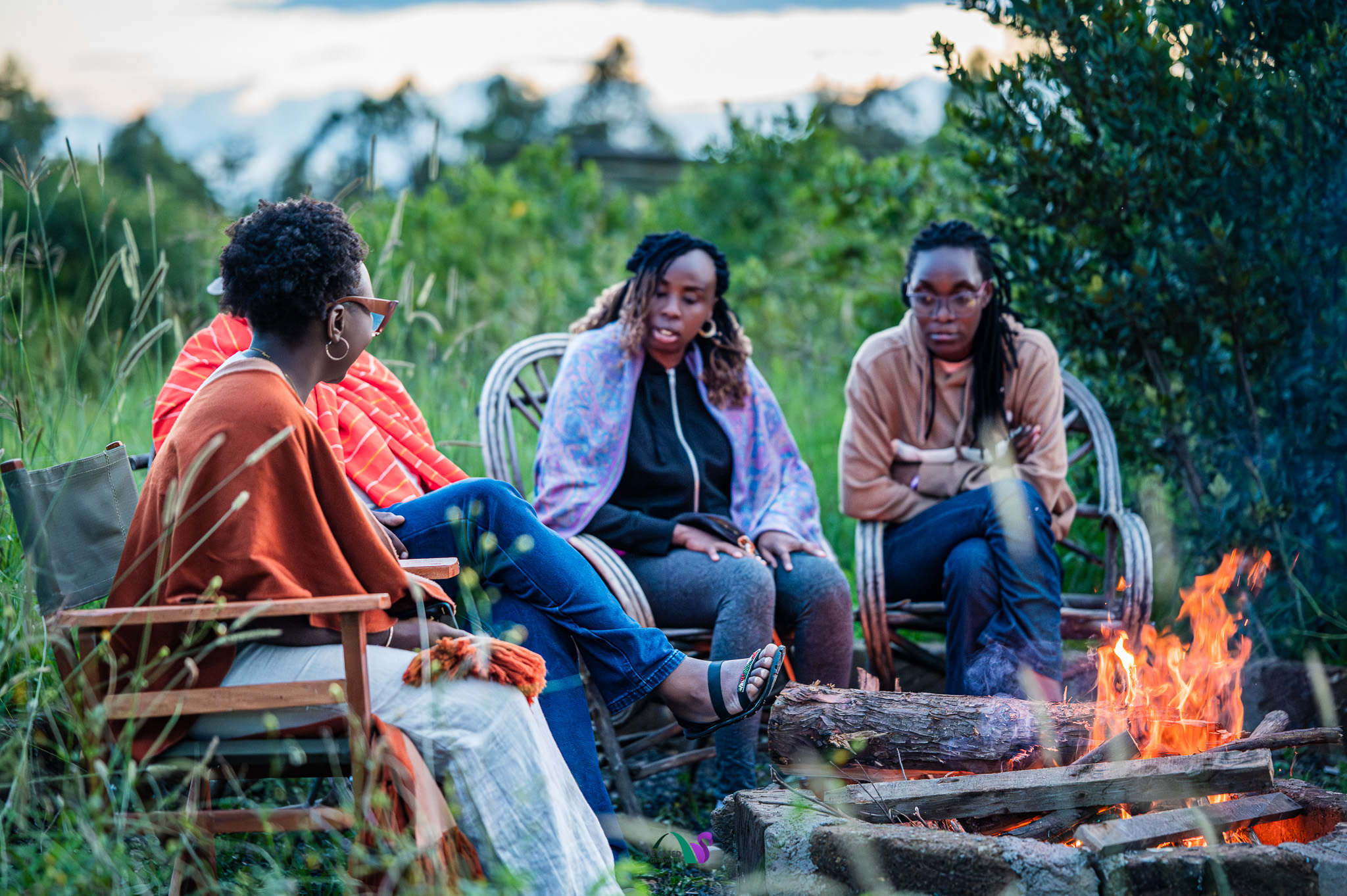 Guests seated around an outdoor campfire